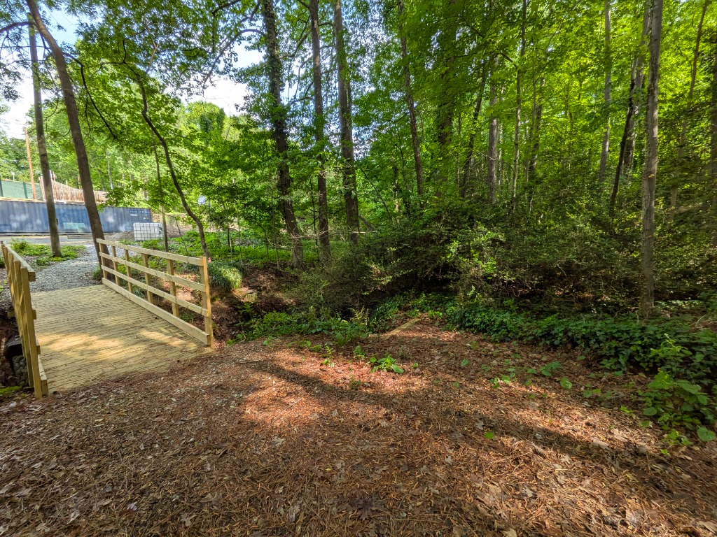 Newly built wooden footbridge over a small creek in the woods